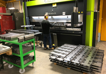 оператор, работающий на станке для гибки с ЧПУ, выполняет настройку оборудования и осуществляет контроль